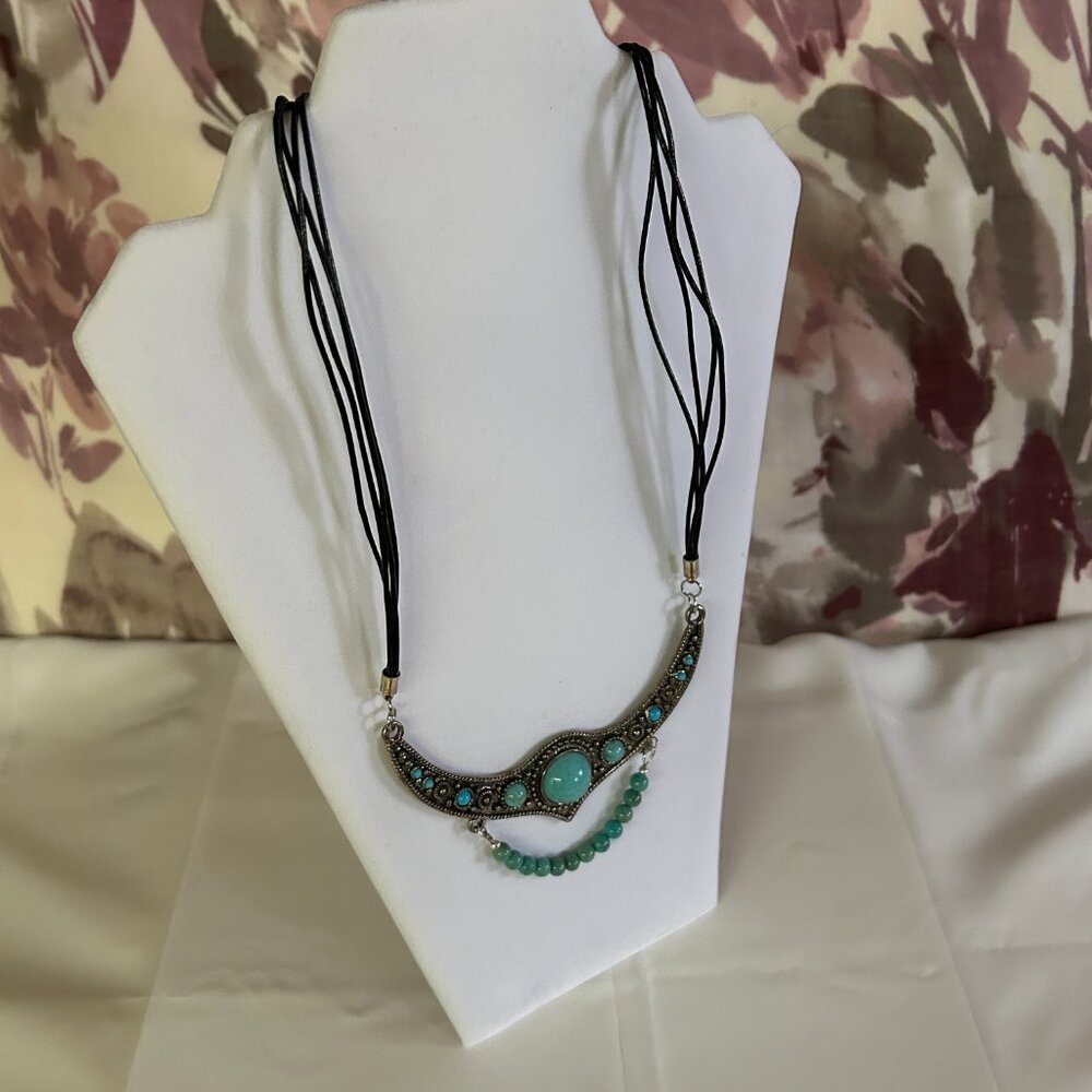 Four long strings of thin black leather chain, large half moon metal pendant